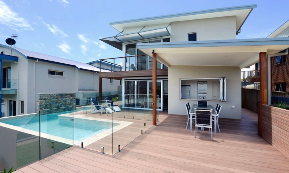 A Large House With a Swimming Pool and a Table and Chairs on the Deck — QBC Constructions In Gerringong, NSW
