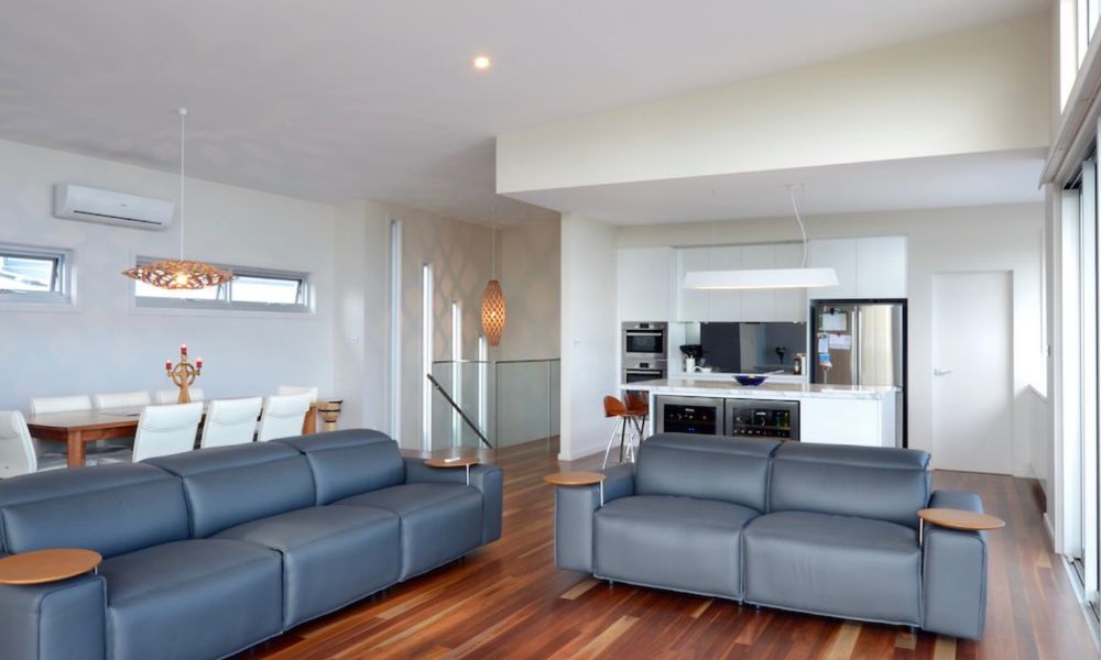 A Living Room With Two Couches And A Kitchen — QBC Constructions In Gerringong, NSW