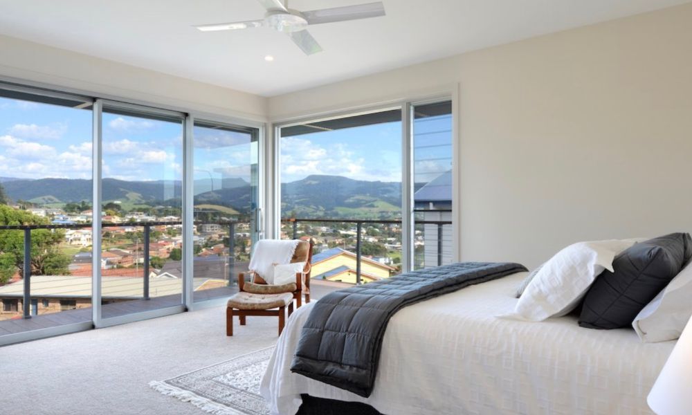 A Bedroom With a Large Bed and a Balcony — QBC Constructions In Gerringong, NSW