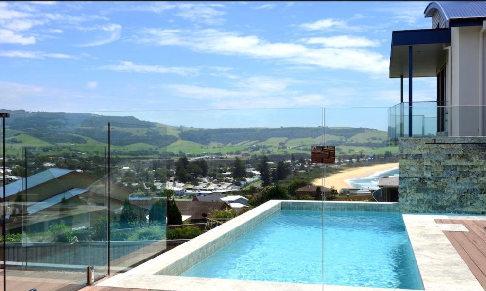A Large Swimming Pool With a View of a City and Mountains — QBC Constructions In Gerringong, NSW