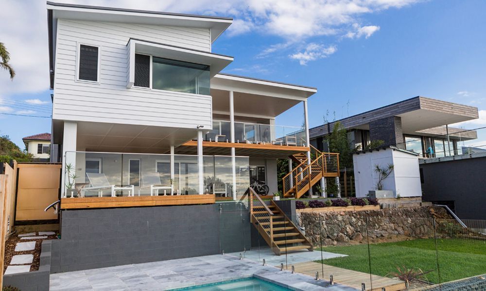 A Large White House With a Swimming Pool in the Backyard — QBC Constructions In Gerringong, NSW