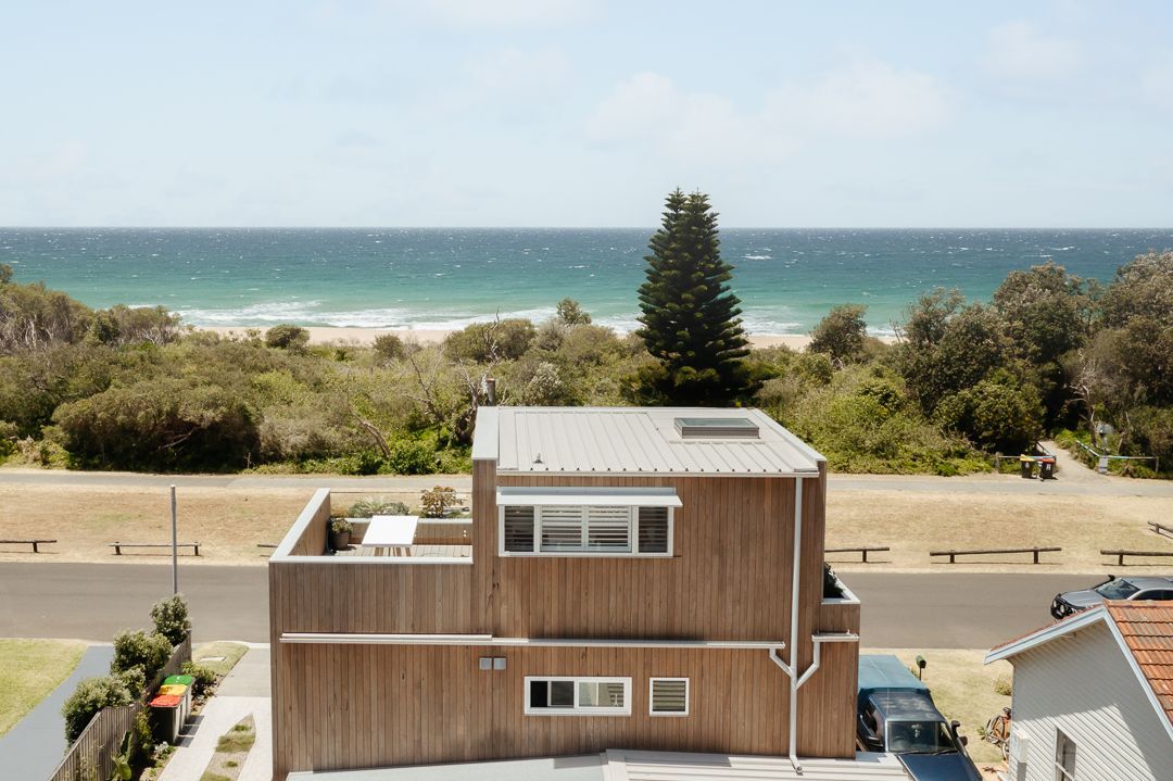 A Modern Three Story House Looking Out To The Ocean With Trees In the Background — QBC Constructions In Werri Beach, NSW