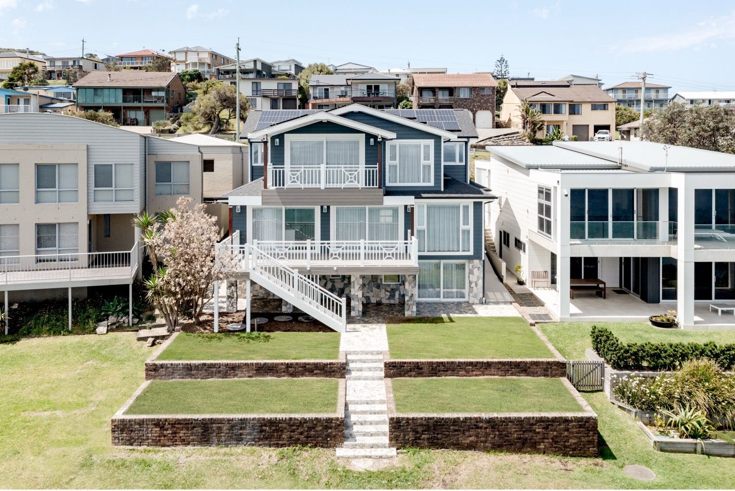 A Large House With Stairs Leading Up to It is Surrounded by Other Houses — QBC Constructions In Gables, NSW