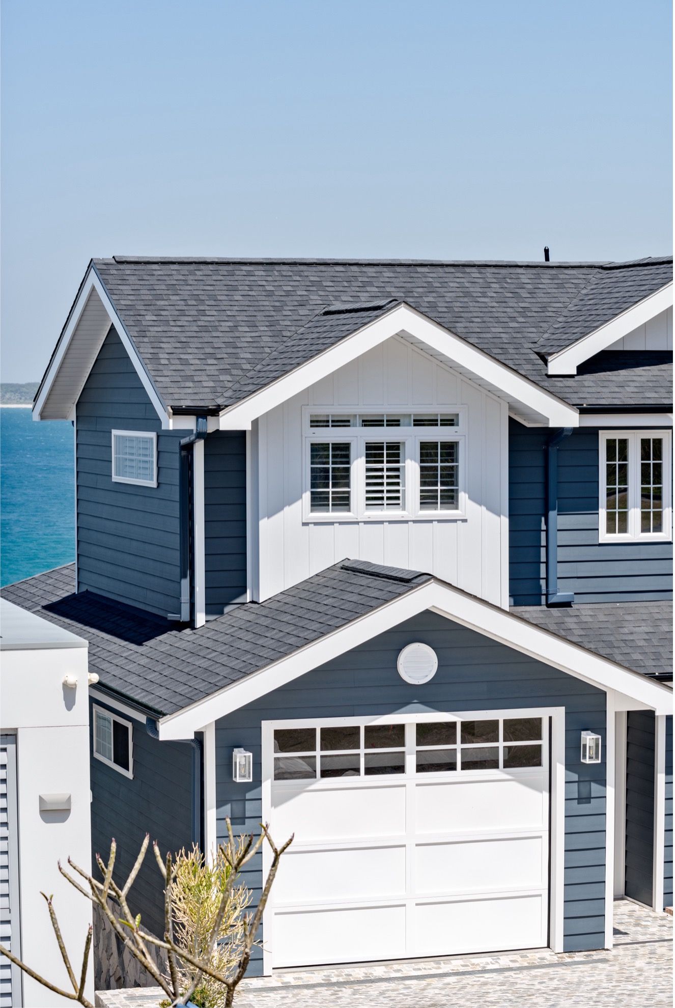 A Blue and White House With a Garage and a View of the Ocean — QBC Constructions In Gables, NSW