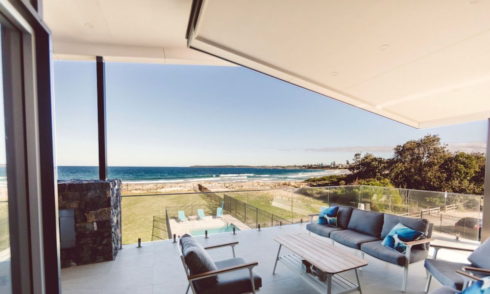 A Balcony With a Couch and Chairs Overlooking the Ocean — QBC Constructions In Shellharbour, NSW