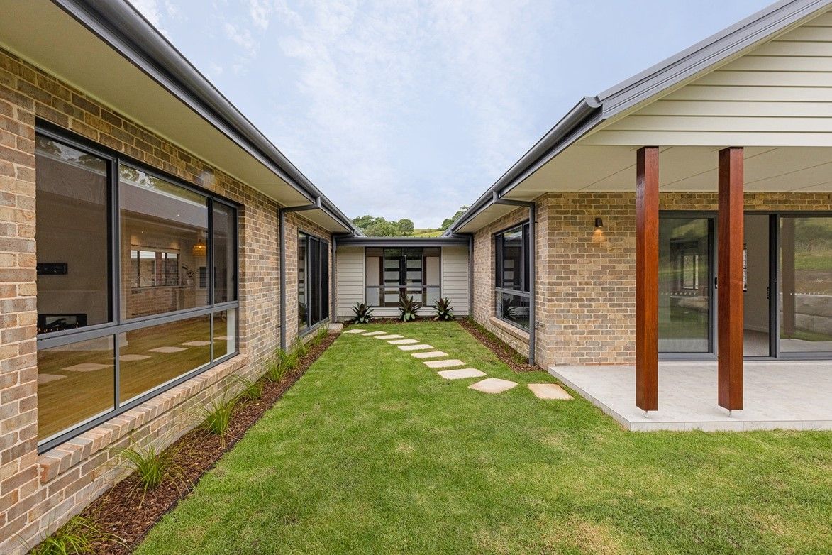 A Brick House With a Large Lawn in the Middle of It — QBC Constructions In Curramore, Queensland
