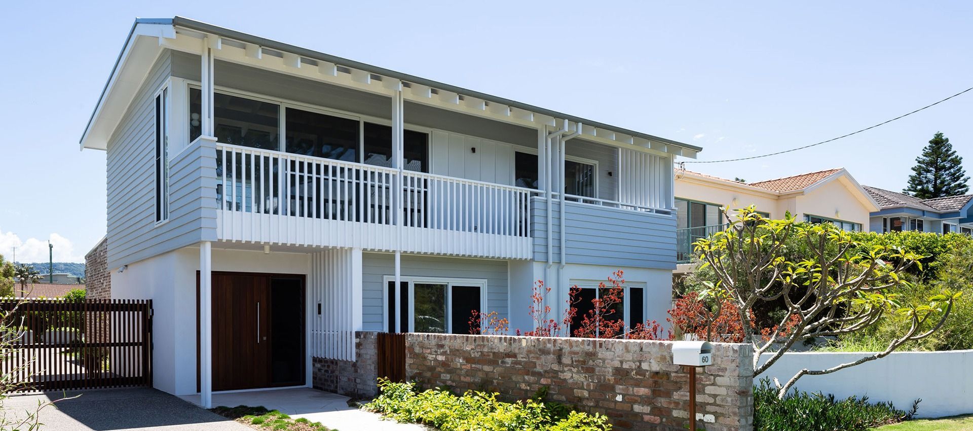 A White House With a Balcony and a Fence in Front of It 
— QBC Constructions In Werri Beach, NSW