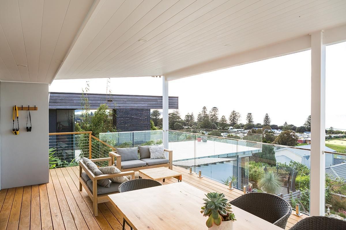 A Wooden Deck With A Table, Chairs, And A Couch — QBC Constructions In Werri Beach, NSW