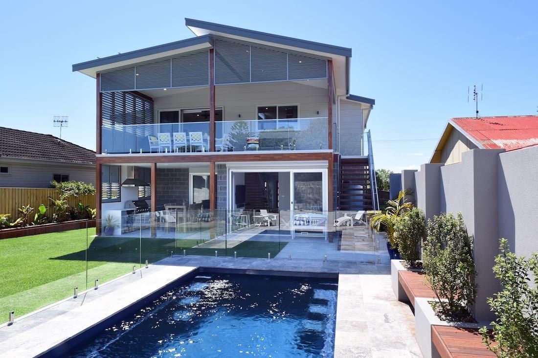 A Large House With A Swimming Pool In Front Of It — QBC Constructions In Werri Beach, NSW