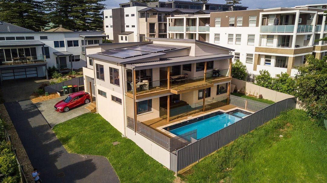 An Aerial View Of A House With A Pool And A Car Parked In Front Of It — QBC Constructions In Shellharbour, NSW