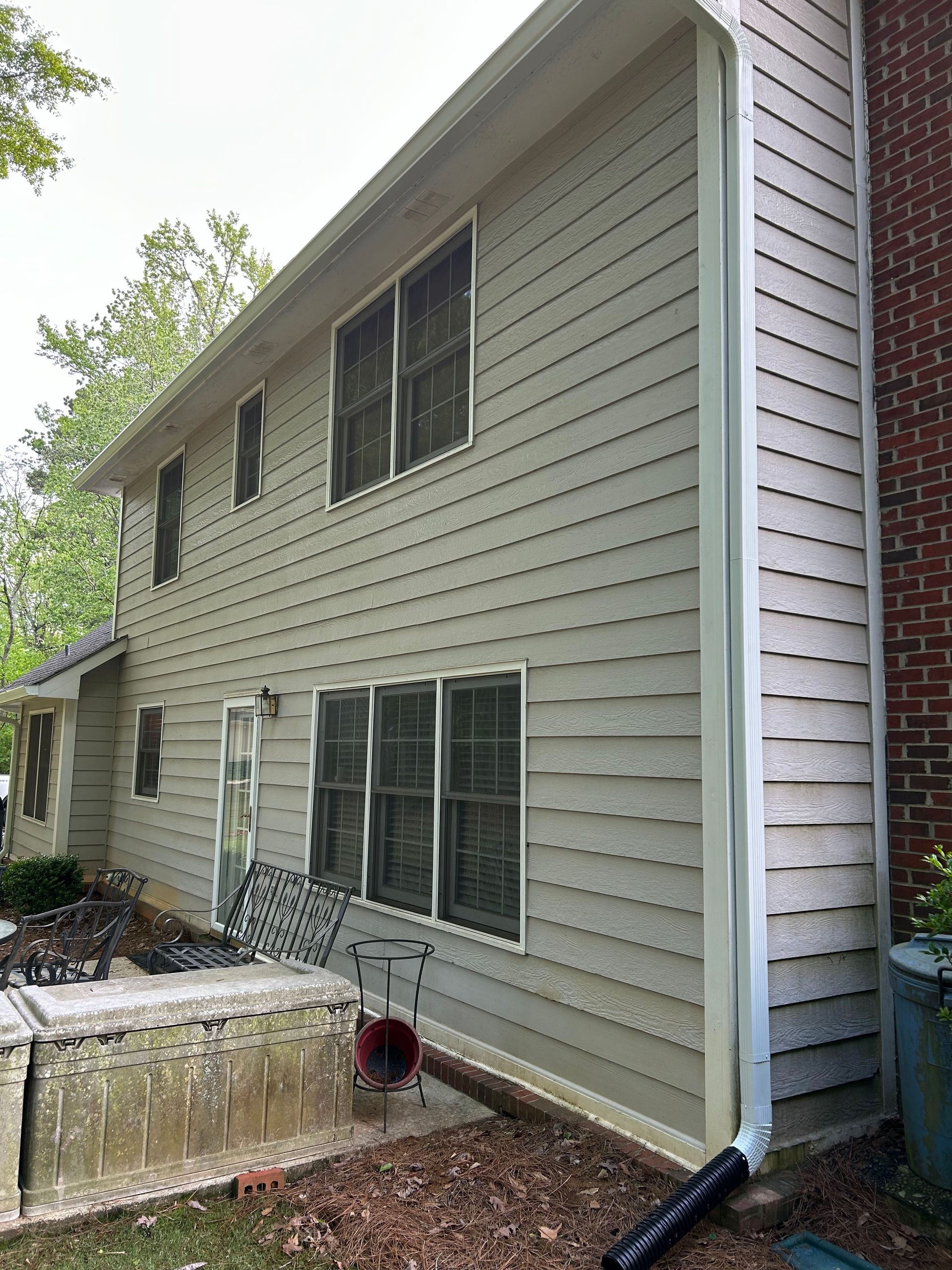 A house with a lot of windows and a drainpipe on the side of it.