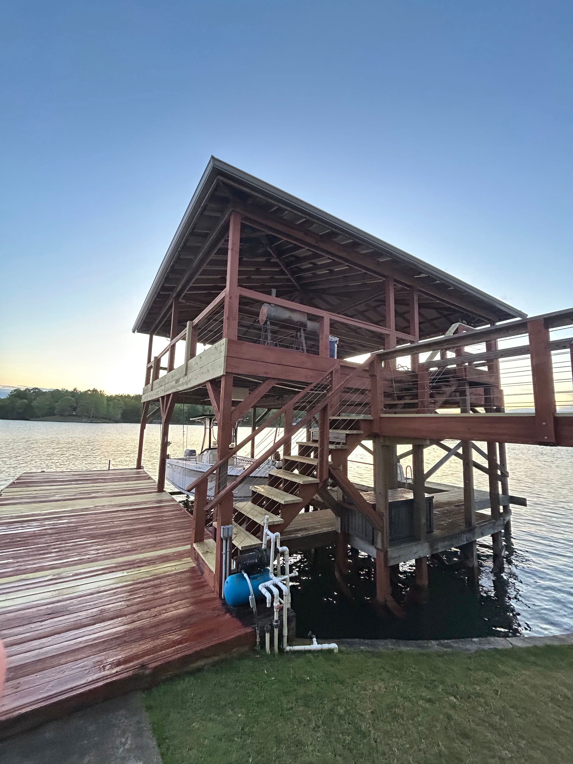 A large wooden dock with stairs leading up to it overlooking a lake.