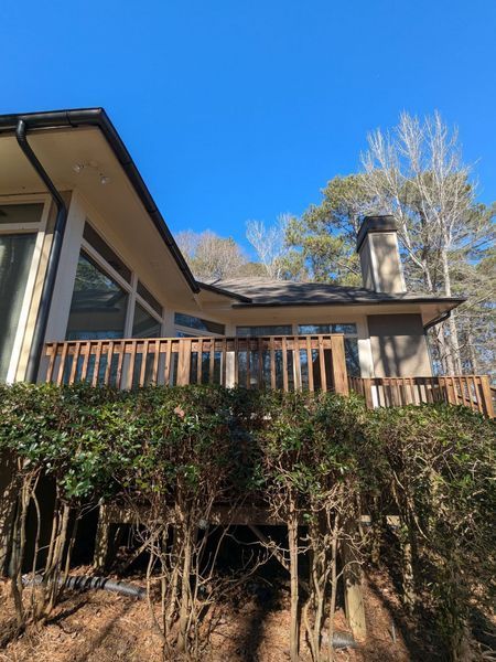 A house with a deck and trees in the background