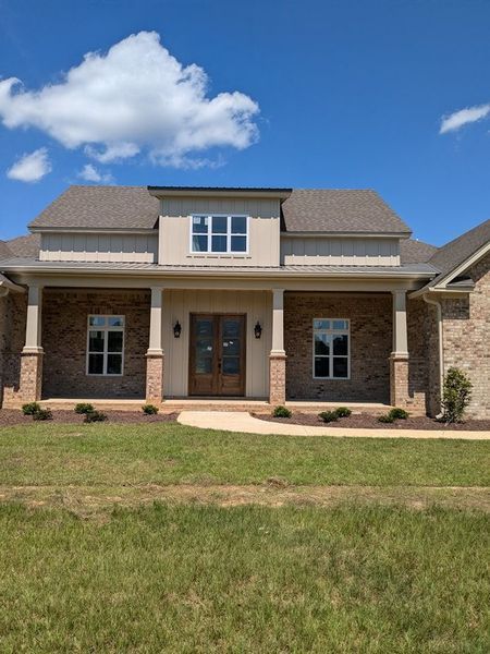 A large house with a porch and a blue sky in the background