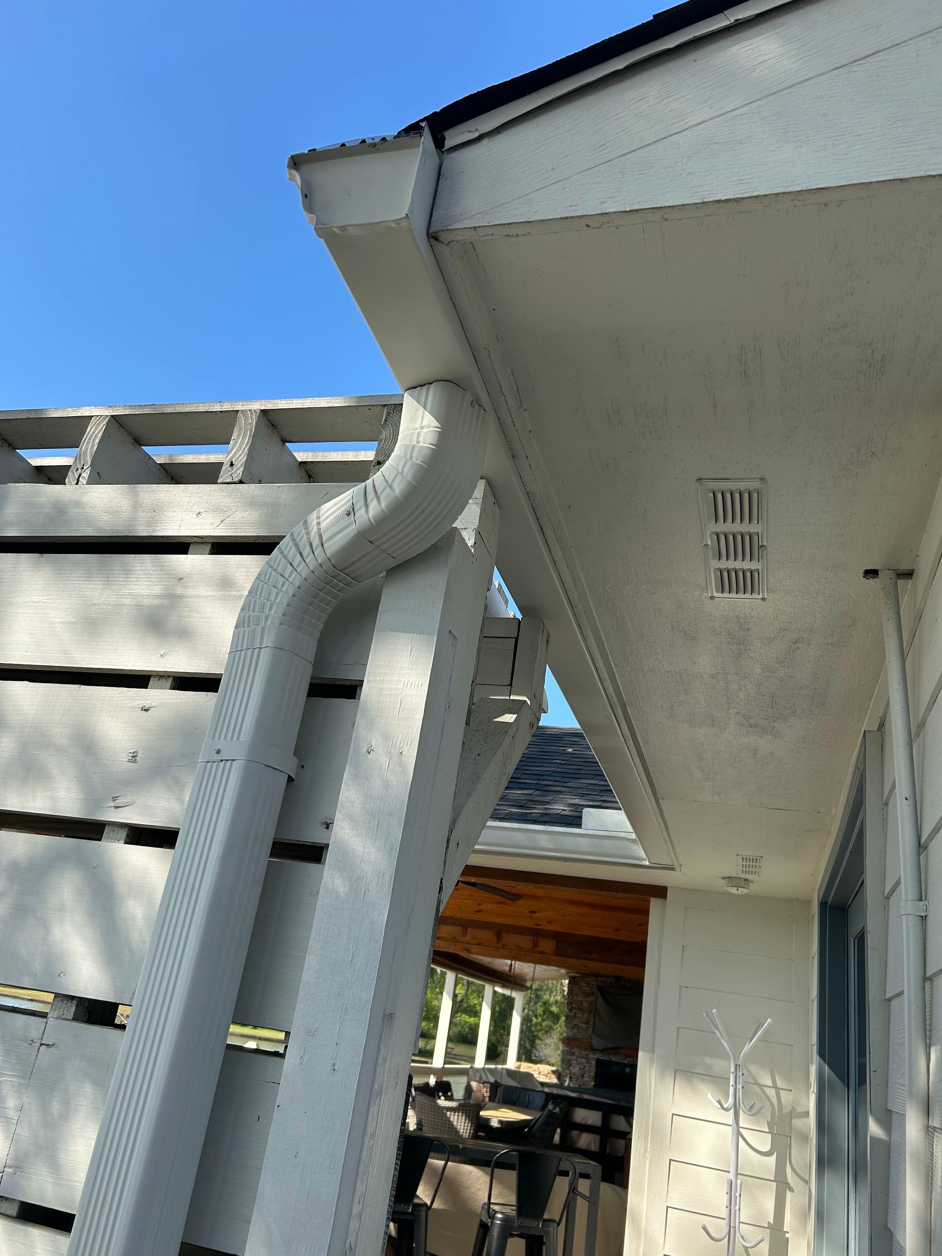 A white house with a gutter on the side of it