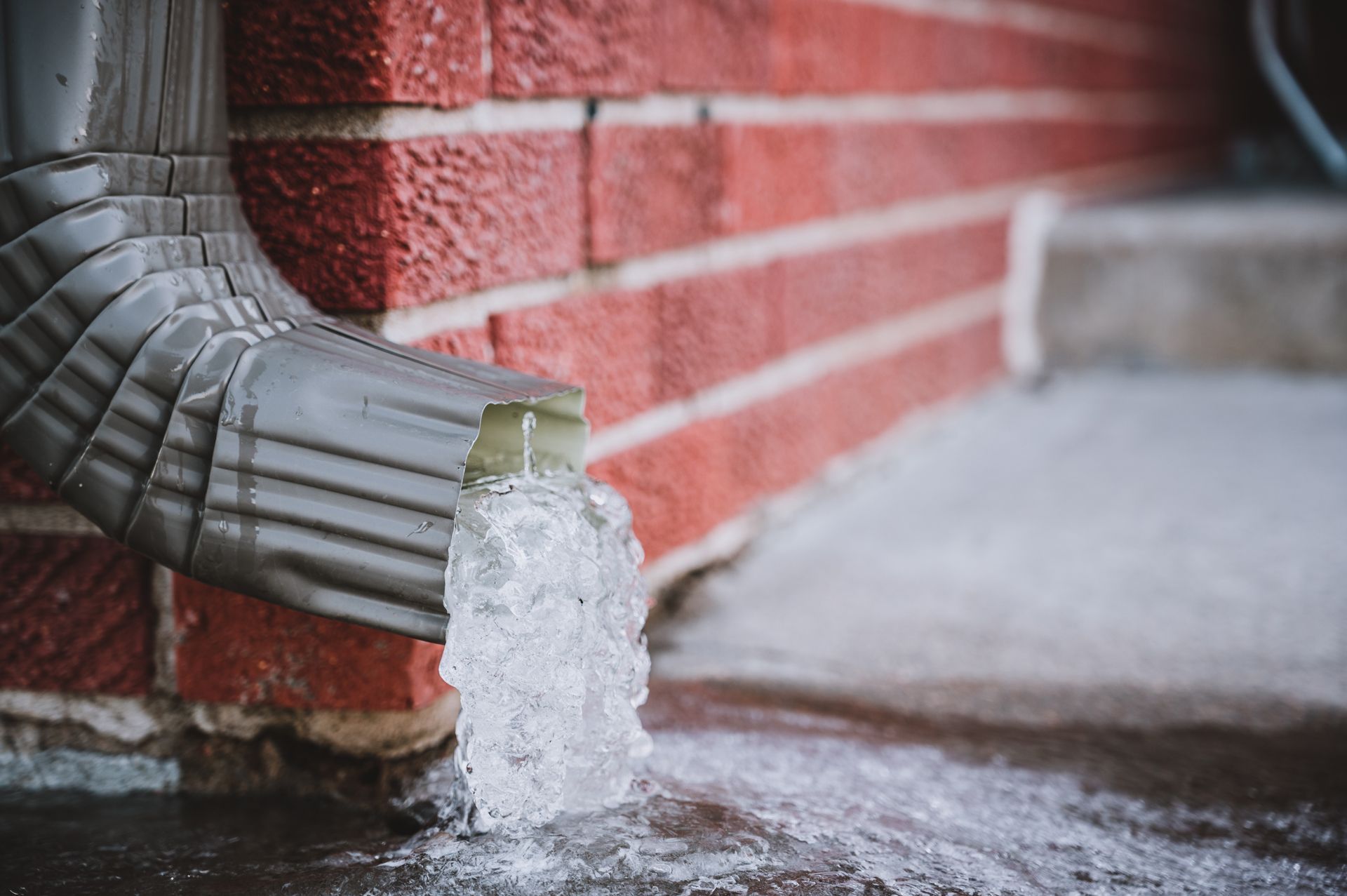 Water is Coming Out of a Gutter on a Brick Wall