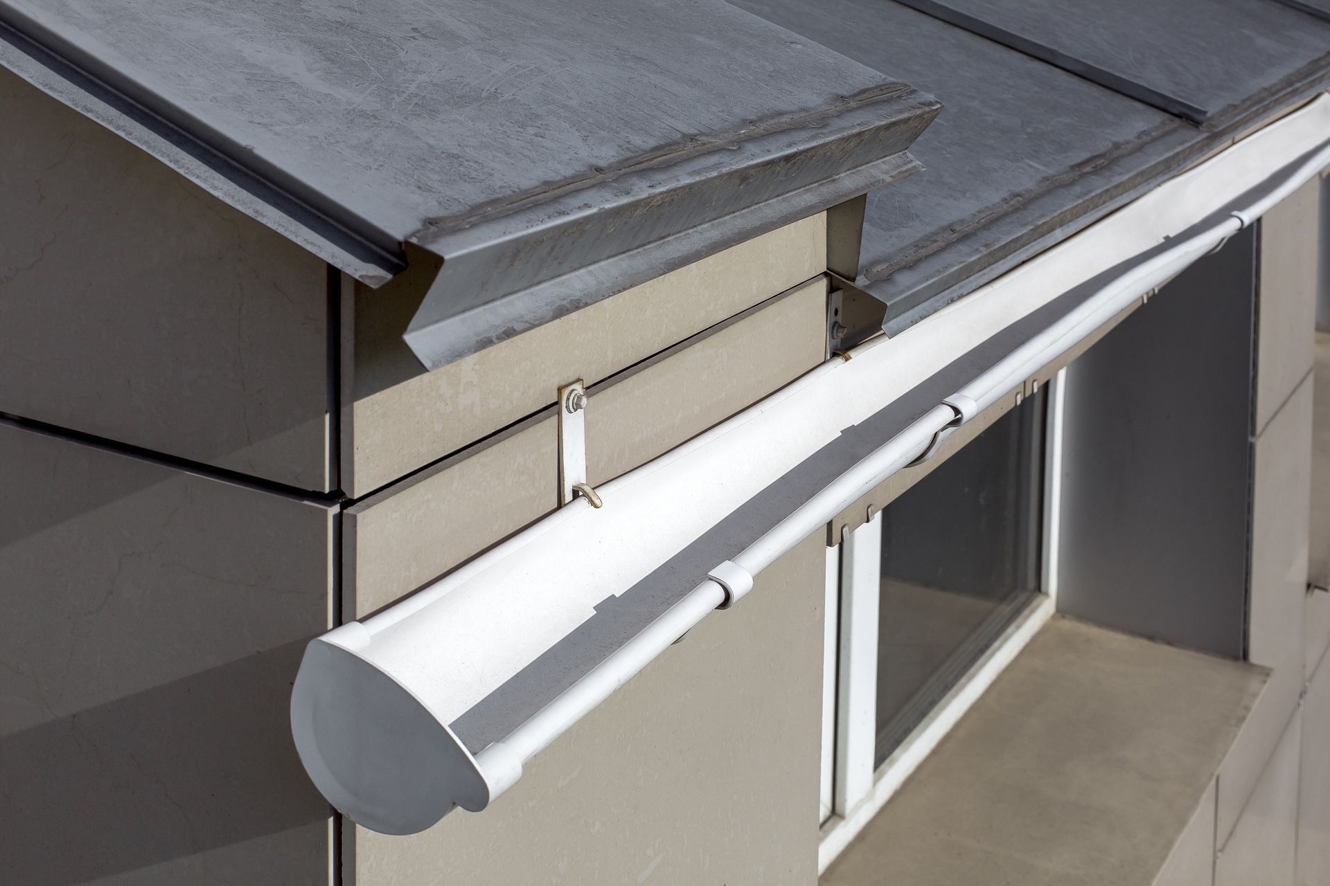 A White Gutter is Attached to the Side of a Building