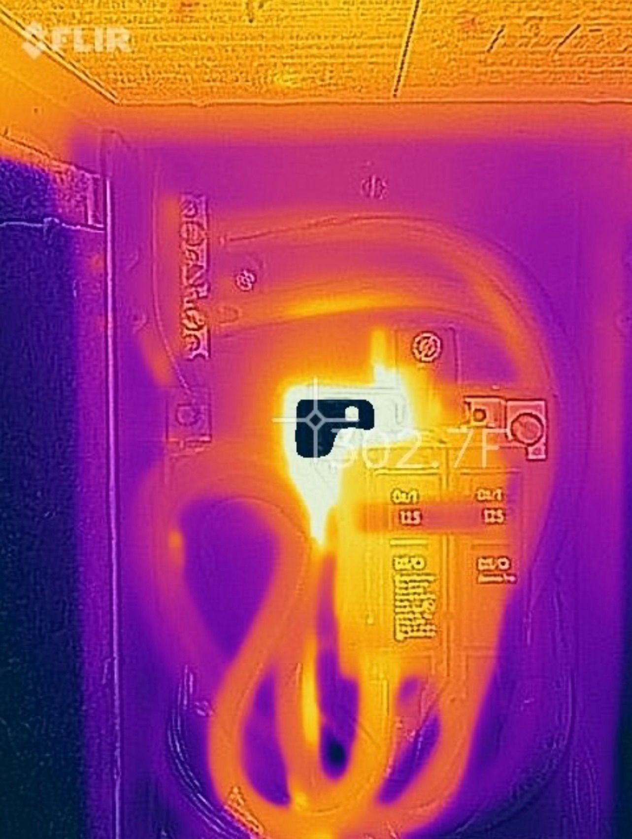 Thermal image of an electrical panel, showing a hot spot in bright yellow, 