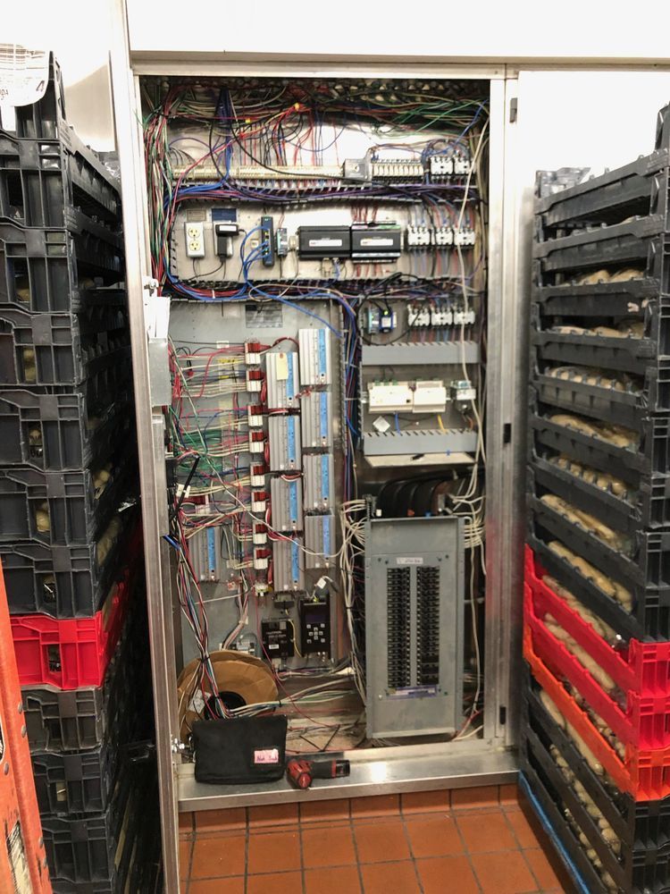 Electrical control panel with complex wiring in a stainless steel cabinet, likely for industrial equipment,