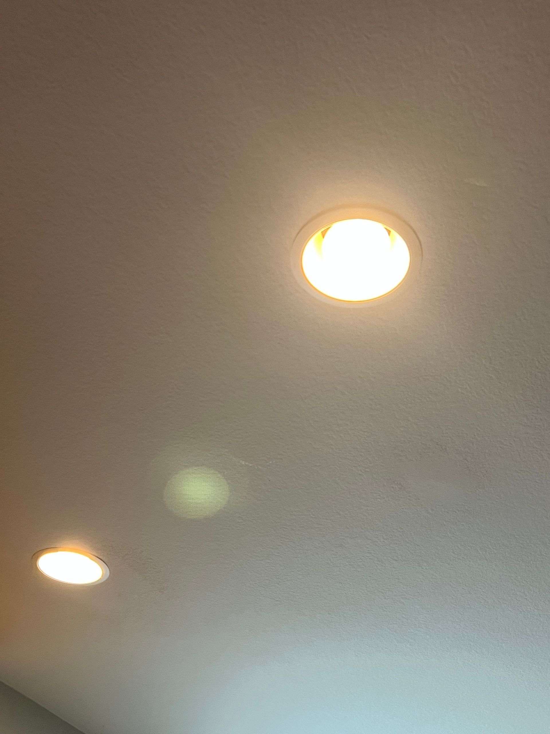 Three recessed ceiling lights are on, illuminating a white ceiling.
