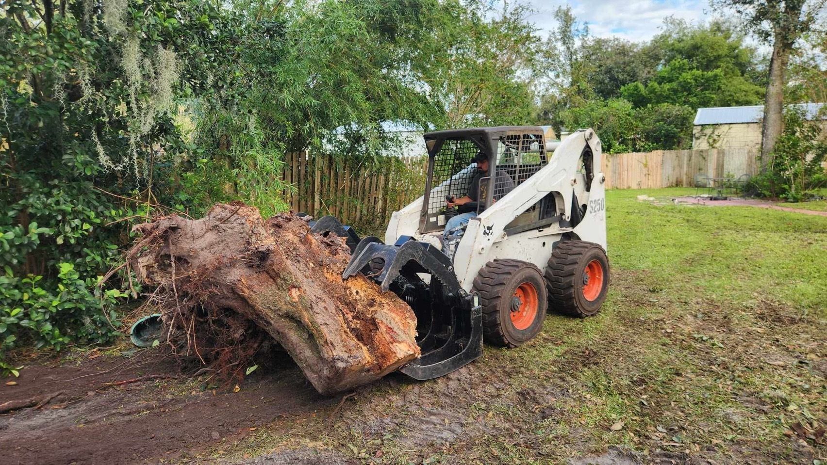 A man is sitting on a small yellow tractor in a field.