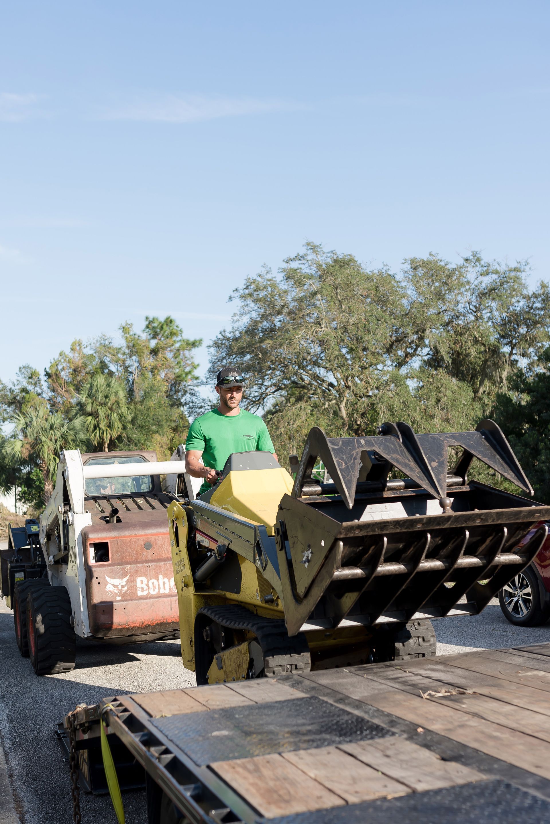 A man is driving a bulldozer on a trailer.