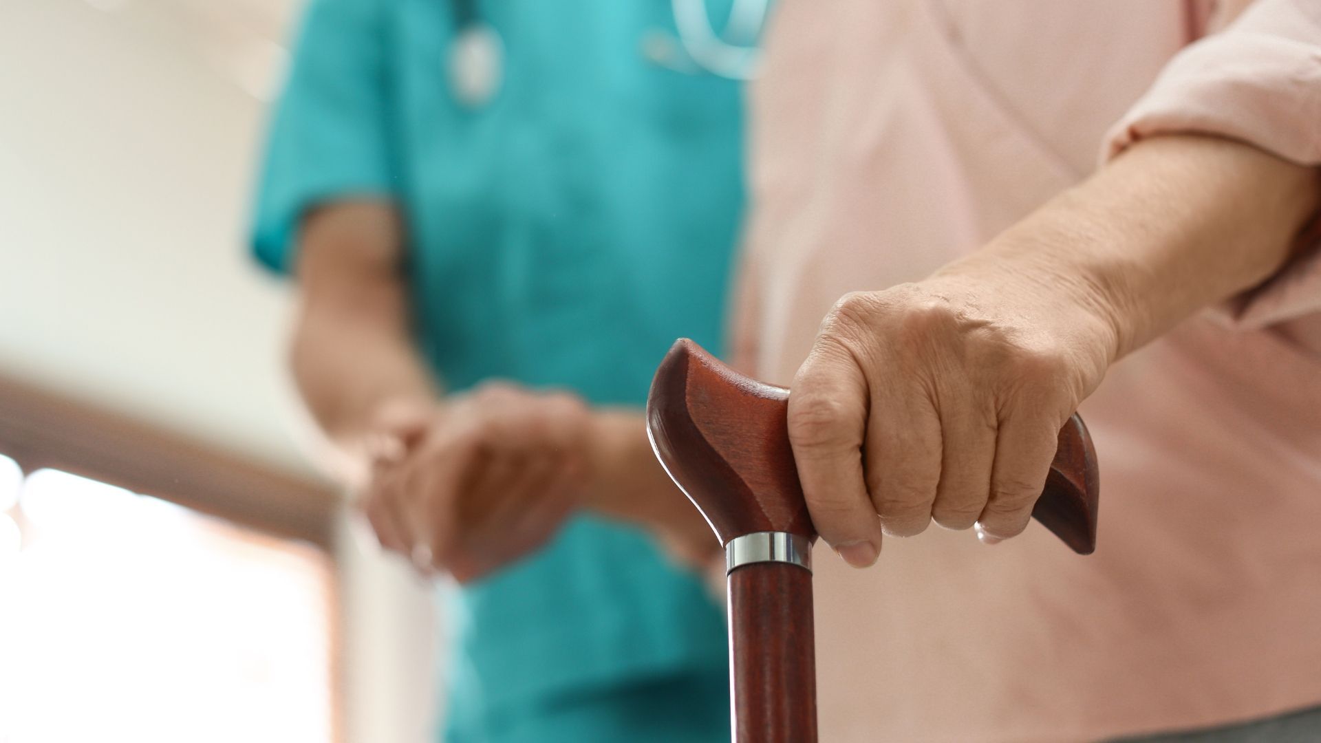 A nurse is talking to an elderly woman in a living room.