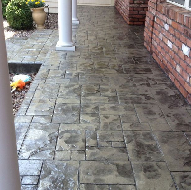 A stone walkway with a brick wall behind it