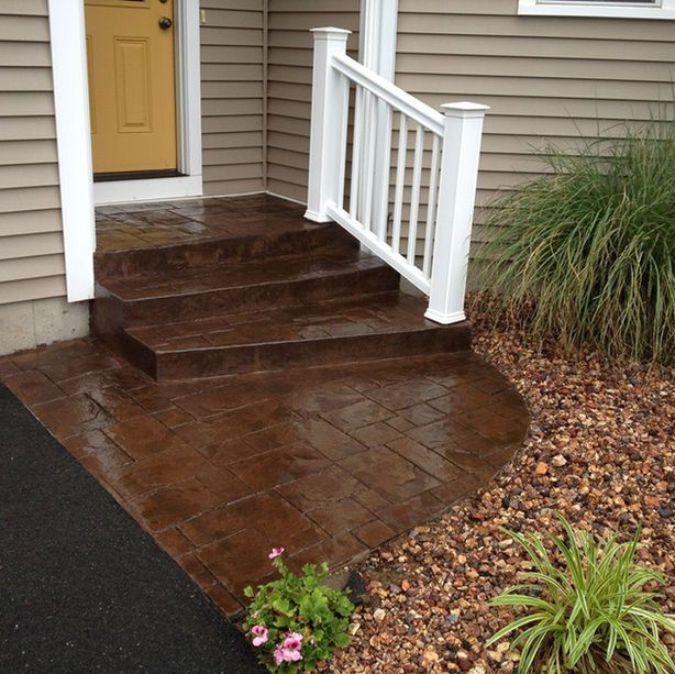 A porch with stairs and a white railing