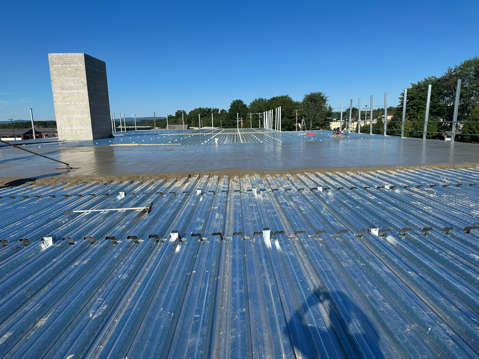 A metal roof with a chimney in the background