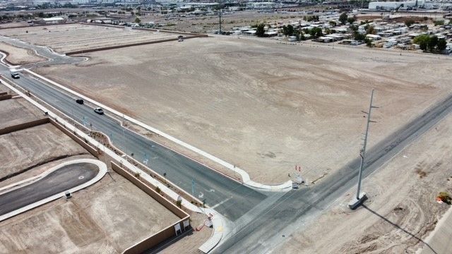 Aerial view of a new road and intersection in a desert landscape. Construction of new development in progress.