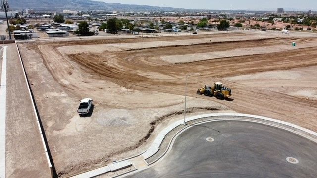 Construction site with a truck, a bulldozer, and graded earth.