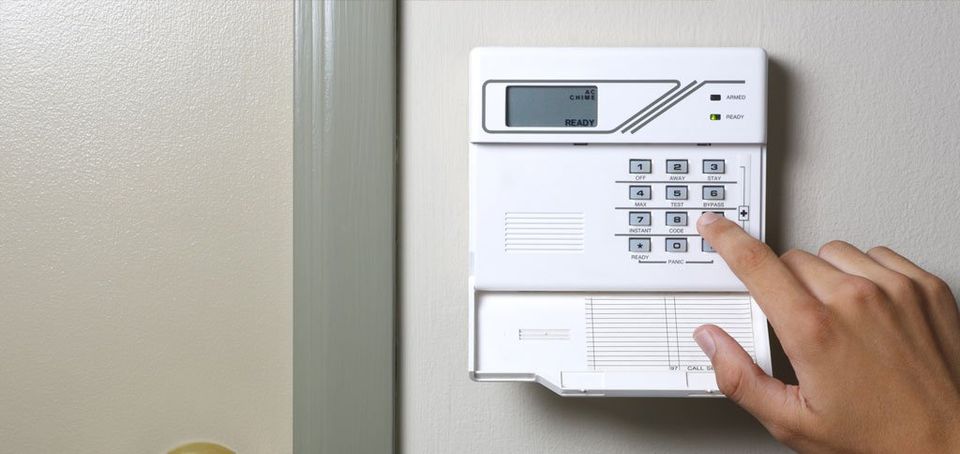 A man activating an alarm system by pressing a key on a keypad.