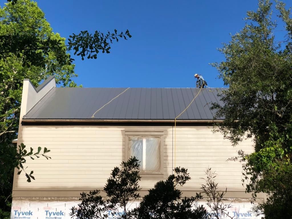 A man is standing on the roof of a house.