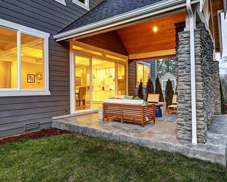 A large house with a covered patio and sliding glass doors.
