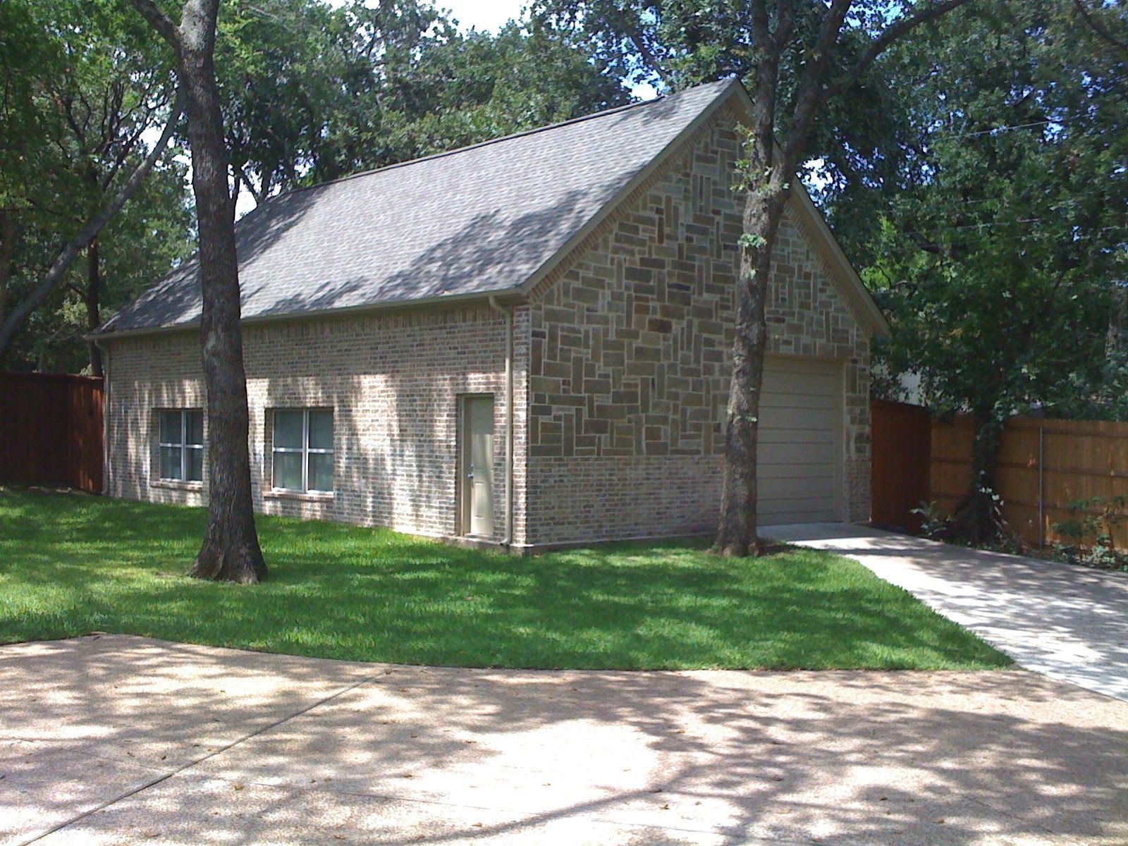 A concrete walkway leading to a large house under construction