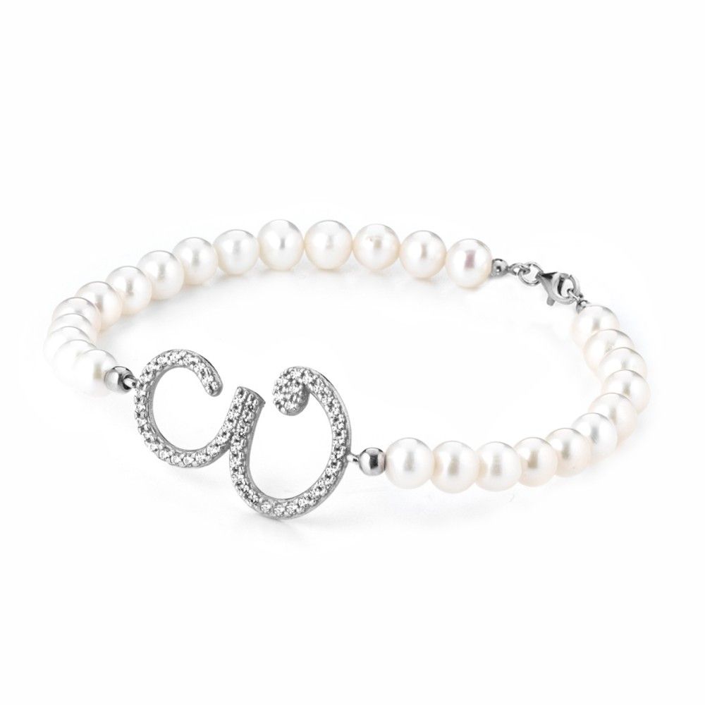 Un braccialetto con perle e diamanti su sfondo bianco