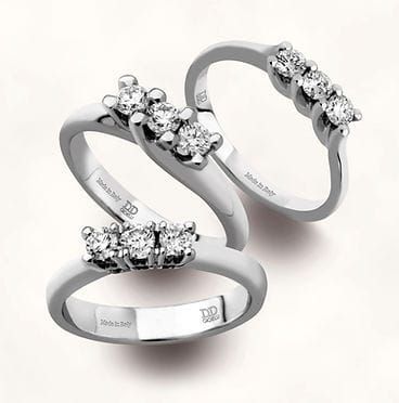 Tre anelli sono impilati uno sopra l'altro su una superficie bianca.