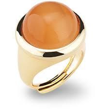 Un anello in oro giallo con una pietra arancione al centro.