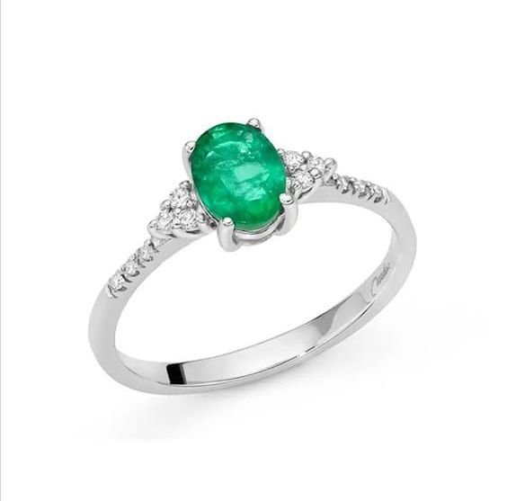 Un anello in oro bianco con uno smeraldo e diamanti