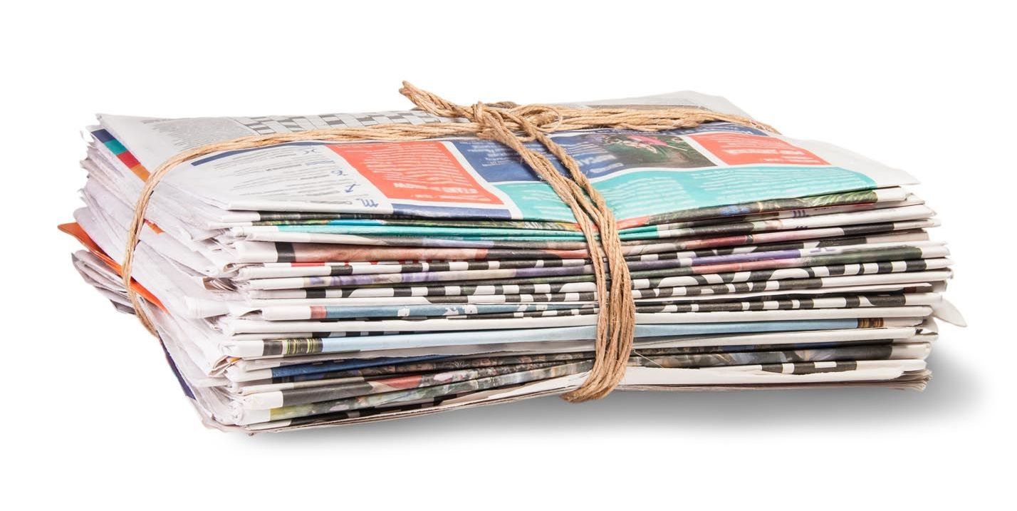 A stack of newspapers tied together with string on a white background.