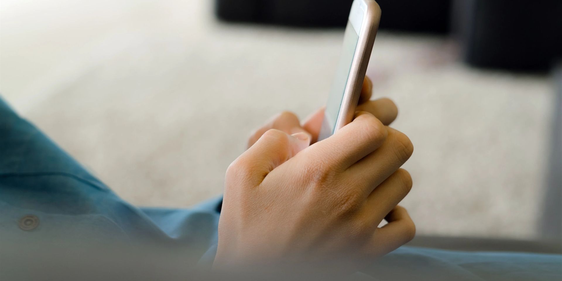A person is holding a mobile phone in their hand.