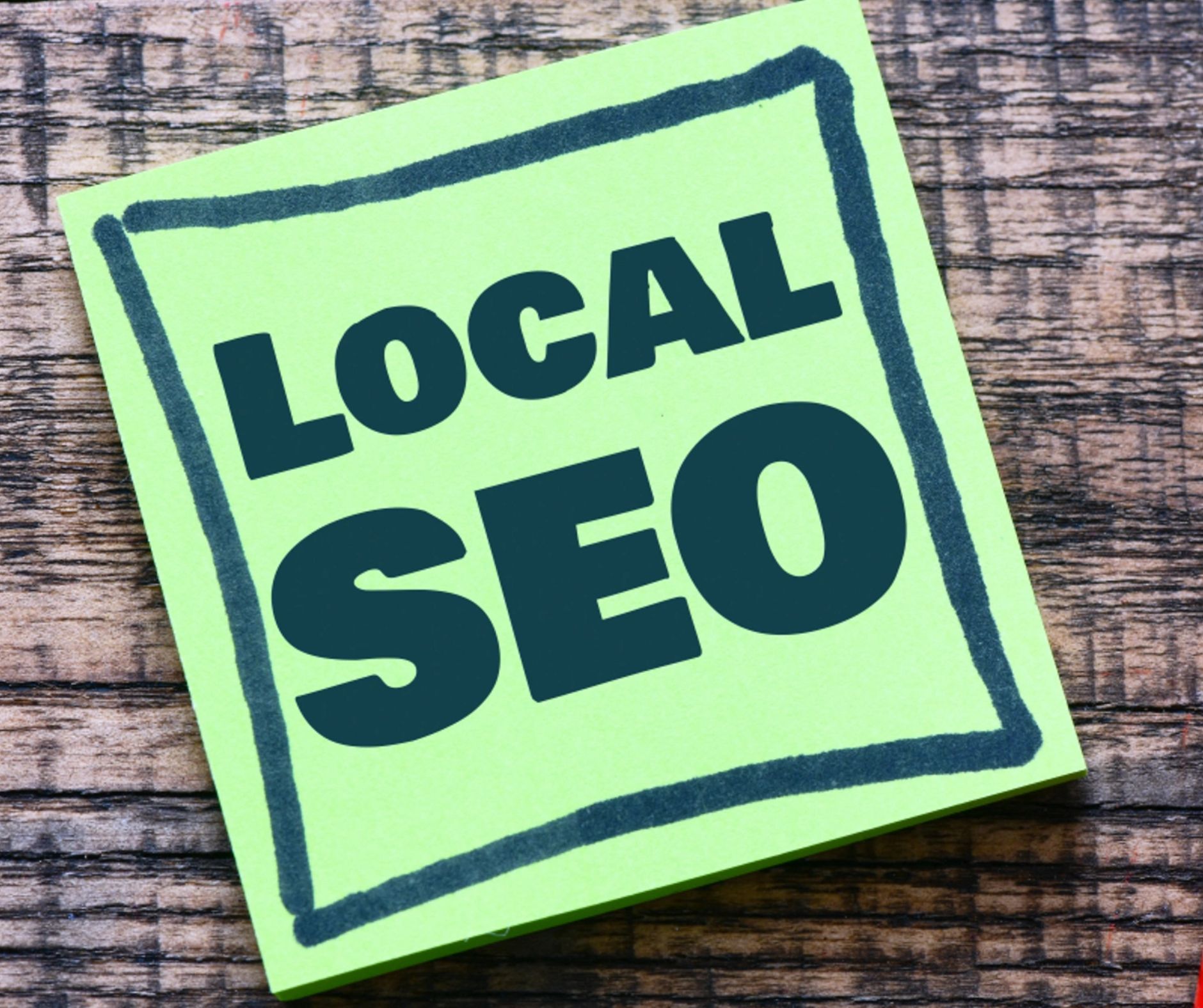 A sticky note on a wooden table that says local seo