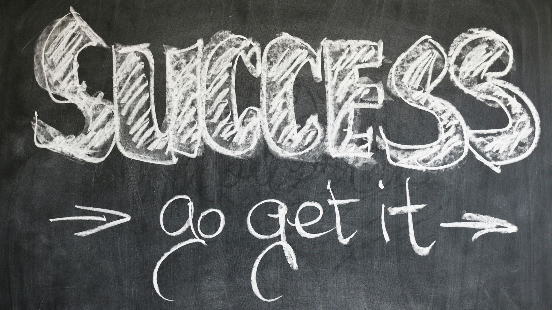 A chalkboard with the words success go get it written in white chalk