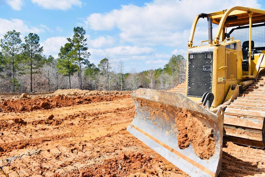 A bulldozer is moving dirt in a field.