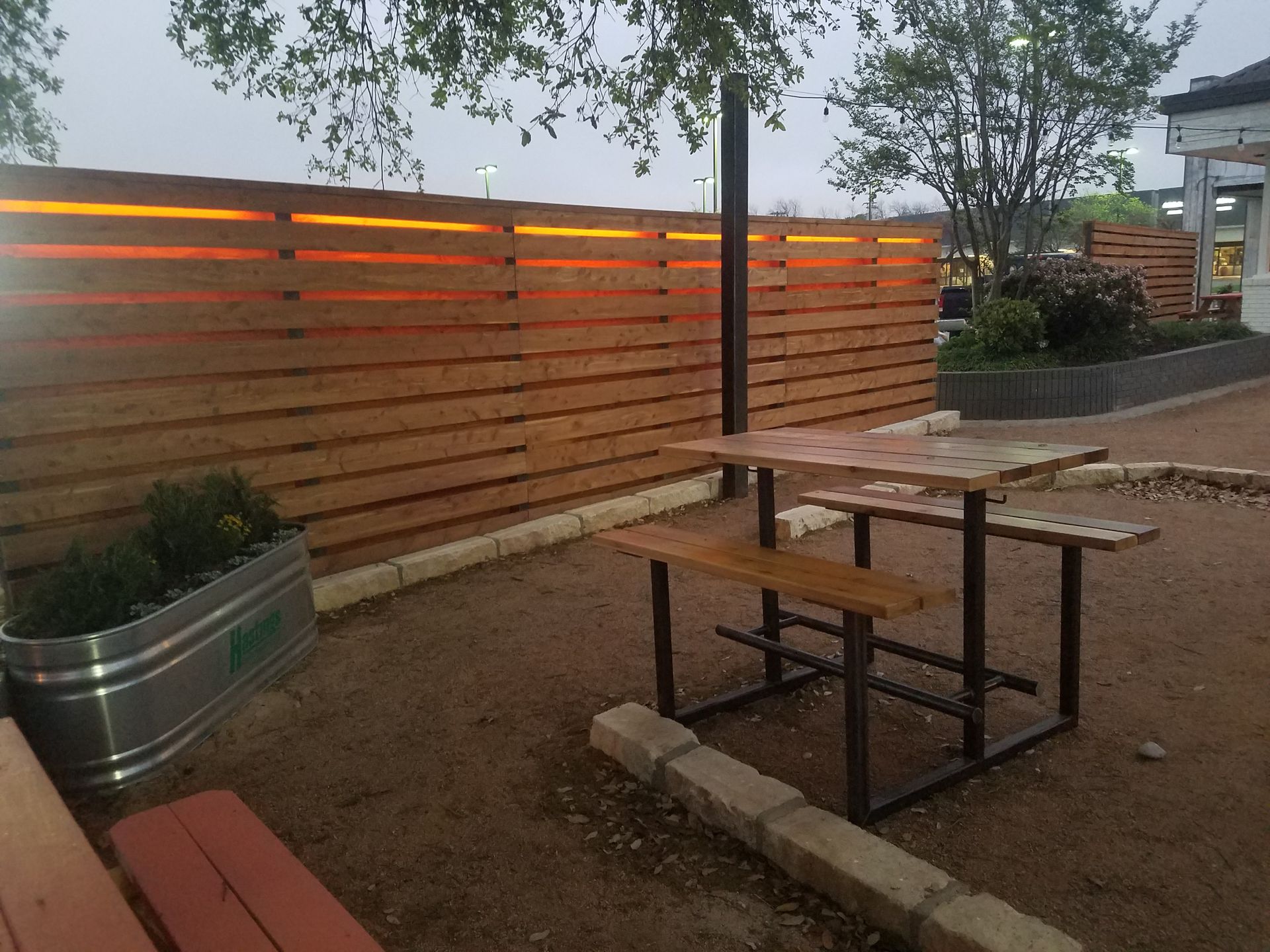 A garden with a table and chairs and a wooden gate