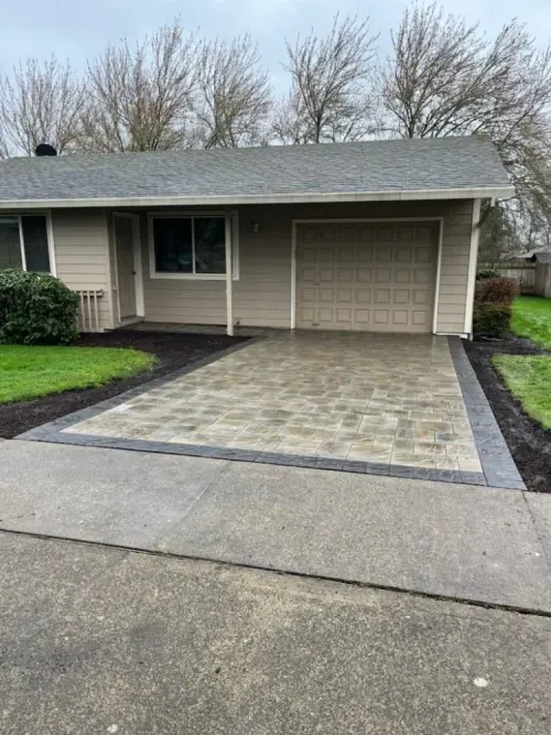 A house with a garage and a driveway in front of it.