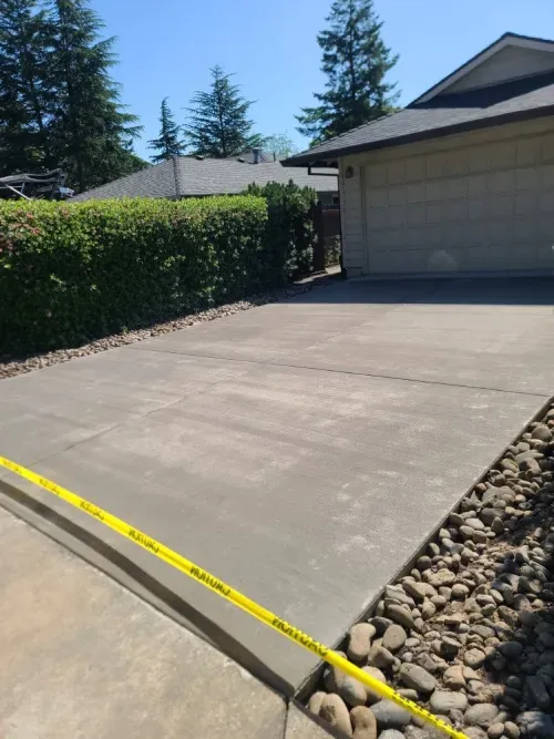 A concrete driveway with a yellow caution tape around it
