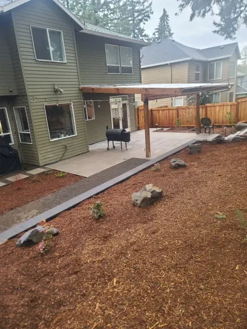 A house with a patio and a pergola in the backyard.
