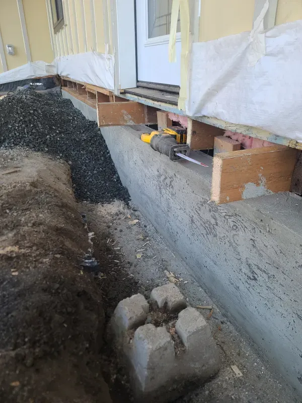 A person is working on a concrete wall next to a door.